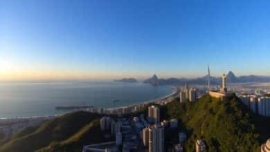 Vista panorâmica da cidade do Rio de Janeiro ao amanhecer, com o Pão de Açúcar e o Cristo Redentor em destaque.