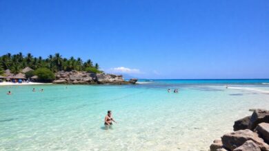 Praia tropical paradisíaca com águas claras, céu azul e pessoas relaxando, representando férias de dezembro