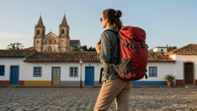 Pessoa apreciando ao pôr do sol em um destino turístico econômico, mochila nas costas, destacando o espírito de aventura e economia durante a viagem.