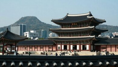 Vista moderna de Seul com templos tradicionais e tecnologia de ponta ao fundo.