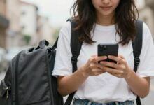 Pessoa viajando com mochila, atento ao ambiente enquanto consulta o celular, representando precaução contra golpes em viagens