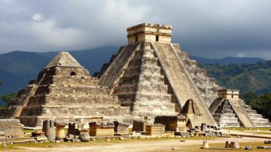 Uma colagem de imagens mostrando as ruínas arqueológicas mais famosas do mundo, como o Coliseu em Roma, Machu Picchu no Peru e as pirâmides de Chichén Itzá no México, sob um céu dramático ao amanhecer.