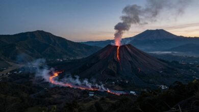 Paisagem impressionante de um vulcão ativo ao entardecer, com rios de lava e montanhas exuberantes ao fundo